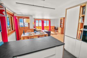 a kitchen and living room with red and white walls at Logement spacieux et confortable in Chateau-d'Oex