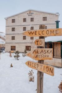un cartel en la nieve frente a un edificio en Alaska Resort en Tsaghkadzor