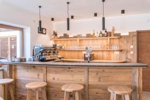 eine Küche mit einer großen Holztheke mit Hockern in der Unterkunft Balbeinhof Apt Hirsch in Lüsen