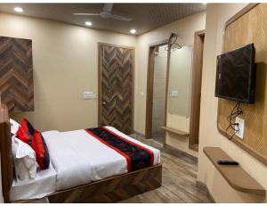 阿姆利則的住宿－Hotel 98, Amritsar，一间卧室配有一张床和一台电视