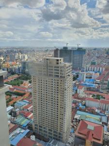 une vue aérienne sur une ville avec un grand bâtiment dans l'établissement SRT Suites - The Skyline, à Phnom Penh