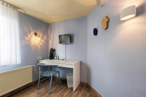 ヴュルツブルクにあるHotel Kunterbunt - by homekeepersのデスク、壁掛けテレビが備わる客室です。