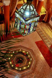 una camera con pavimento a mosaico e lampadario a braccio di Riad Lila a Marrakech