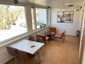 a waiting room with tables and chairs and a window at Motel '69 Lovisa in Loviisa