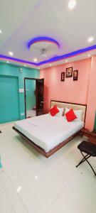 a bedroom with a large white bed with red pillows at Hotel Ananya Inn in Varanasi