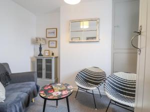 a living room with a couch and two chairs at 5 Bryn Tirion in Blaenau-Ffestiniog