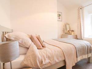 a bedroom with a bed with a blanket and a lamp at 5 Bryn Tirion in Blaenau-Ffestiniog
