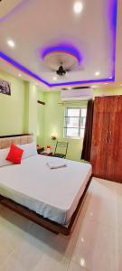 a bedroom with a large bed with a purple ceiling at Hotel Ananya Inn in Varanasi