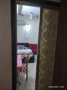 a door to a room with a table and a bed at Short stay service apartment in Dhaka