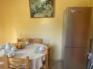 a kitchen with a table with a silver refrigerator at Tonia’s house in Leonidio
