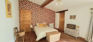 a bedroom with a bed and a tv on a wall at Villa Misanid écrin de verdure à 15mm de la cité de Carcassonne in Mas-des-Cours