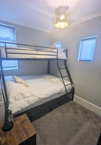 a room with two bunk beds and a table at Lincoln Lodge, 2-bedroom,2-bathroom,ground floor flat in Southend-on-Sea