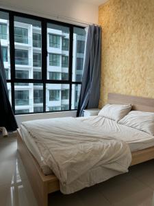 ein Bett in einem Schlafzimmer mit einem großen Fenster in der Unterkunft Lovely Romantic HomeStay @Cheras in Kuala Lumpur