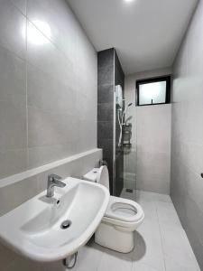 ein weißes Bad mit einem Waschbecken und einem WC in der Unterkunft Lovely Romantic HomeStay @Cheras in Kuala Lumpur