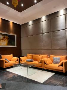 ein Wartezimmer mit orangenen Sofas und einer Wand in der Unterkunft Lovely Romantic HomeStay @Cheras in Kuala Lumpur