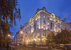 a large white building on a city street at night at Mamaison Hotel Riverside Prague in Prague