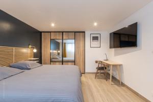 sypialnia z łóżkiem, biurkiem i telewizorem w obiekcie Calme absolu, terrasse et parking entre Paris et Disney w mieście Vaires-sur-Marne