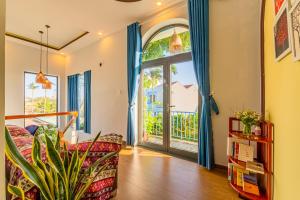 - un salon avec un canapé et une grande fenêtre dans l'établissement Hoi An Paddy House Homestay, à Hội An
