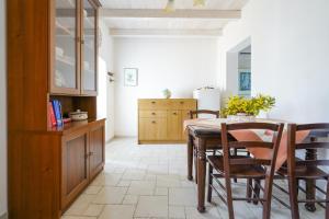 Una cocina con mesa y sillas y un refrigerador. en Casina delle Rose - Levante, en Polignano a Mare