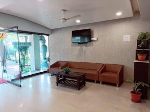 a living room with a couch and a tv at Aquarius Resort in Pune