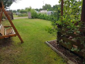 a garden with a bench in the grass at Domek letniskowy Zacisze pod Sosnami Trzęsacz in Trzęsacz