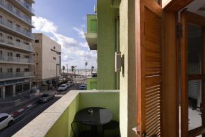 balkon ze stołem i widokiem na ulicę w obiekcie Residence Suites BY RAPHAEL HOTELS w Tel Awiwie