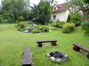 a yard with two picnic tables and a fire pit at Katka a Martin samostatný apartmán s vlastným vchodom in Liptovský Mikuláš