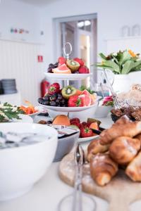 uma mesa com diferentes tipos de frutas e produtos hortícolas em Sandkaas Badehotel em Allinge