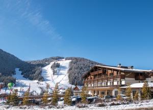 a ski lodge with a snow covered mountain in the background at Hotel Condor in San Vigilio Di Marebbe