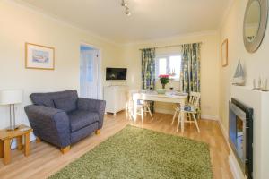 uma sala de estar com um sofá azul e uma mesa em The Quarter Deck em Aldeburgh