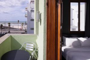 Pokój z łóżkiem i stołem oraz widokiem na plażę w obiekcie Residence Suites BY RAPHAEL HOTELS w Tel Awiwie