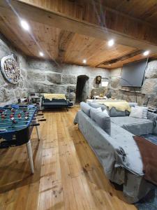 a living room with a pool table and a stone wall at Casa da Poça in Baião