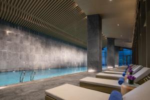 寧波市にあるWonderland Hotel Ningbo International Conference Centerのラウンジチェアとスイミングプール付きのホテル内のプールを利用できます。