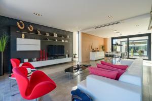 a living room with a white couch and red chairs at M4R Architect House Llubi in Llubí
