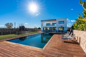a house with a swimming pool with a wooden deck at M4R Architect House Llubi in Llubí