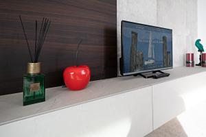 une télévision et une pomme rouge assise sur un comptoir dans l'établissement APARTMENT YIN & YANG - Regarda Travel, à Lazise