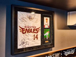 a picture of a baseball jersey hanging on a wall at Rakuten STAY x EAGLES 102 with terrace in Sendai