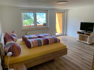 Cette chambre comprend un canapé avec des oreillers et une télévision. dans l'établissement Waldhäusl, à Matrei in Osttirol