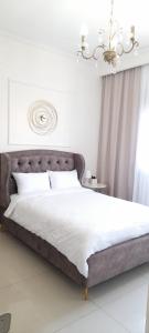 ein Schlafzimmer mit einem großen Bett mit einem Kronleuchter in der Unterkunft Regina's place in Or ‘Aqīvāh