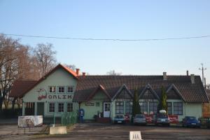 un bâtiment avec des voitures garées devant lui dans l'établissement Hotelik Orlik, à Legnickie Pole