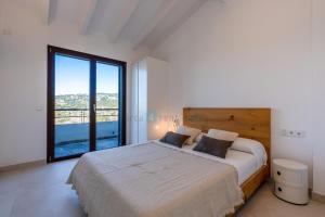 ein Schlafzimmer mit einem großen Bett und einem großen Fenster in der Unterkunft M4r 02 Can Parra Port de Andratx in Andratx