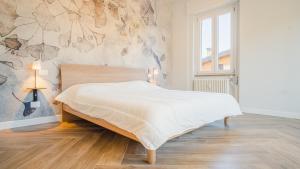 1 dormitorio con 1 cama y una pared con flores en The Roman Villa View - Italian Homing, en Desenzano del Garda