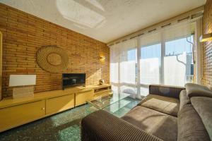 uma sala de estar com um sofá e uma televisão em HomeHolidaysRentals Miracel - Costa Barcelona em Malgrat de Mar