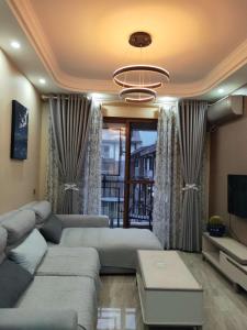 uma sala de estar com um sofá e uma televisão em Jiamen Inn em Emeishan