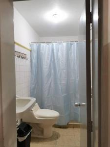 a bathroom with a white toilet and a sink at Casa piso 2 sin ascensor Medellín Centro lugar seg in Medellín