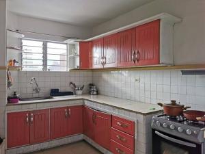 a kitchen with red cabinets and a stove top oven at Casa piso 2 sin ascensor Medellín Centro lugar seg in Medellín