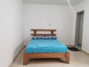 a bedroom with a bed with a blue blanket at Casa piso 2 sin ascensor Medellín Centro lugar seg in Medellín