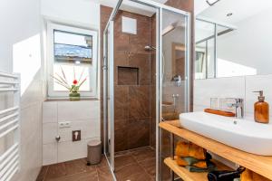 y baño con ducha y lavabo blanco. en STOAMAT Appartements en Lofer