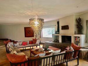 a living room with couches and a chandelier at Africa House Malawi in Lilongwe