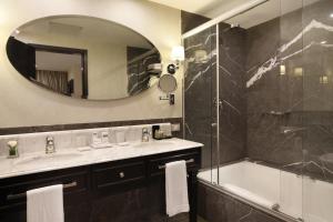 a bathroom with a sink and a tub and a mirror at Miramar By Windsor Copacabana in Rio de Janeiro